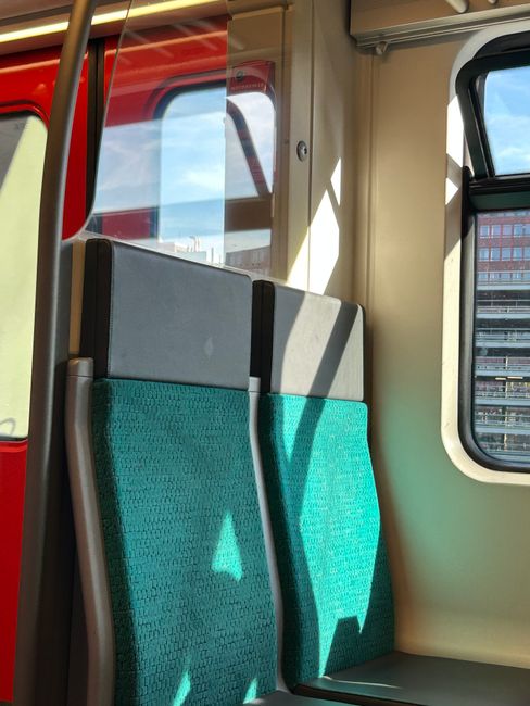 Inside view of a clean, well-maintained train carriage at Eden Park station, featuring light blue plastic seats with black mesh backing, arranged along the sides of the carriage. The flooring appears